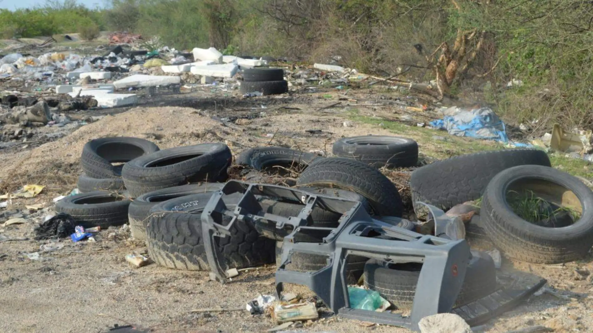 Basura llantas arroyo calle